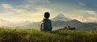 © Ilgun - An Asian boy is seated on a grassy hill with a mountain in the background providing a picturesque scene suitable for a copy space image