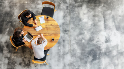 Canvas Print - A top-down view of three professionals working at a round wooden table, concrete-style background, business concept. Generative AI