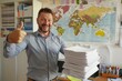 © DK_2020 - A content educator with a stack of student papers giving a thumbs up in a classroom with a world map on the wall