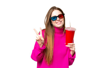 Canvas Print - Young woman holding soda while watching a 3D movie smiling and showing victory sign