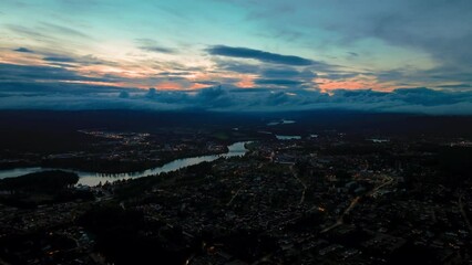 Wall Mural - Drone of beautiful sunset sky above illuminated city with river