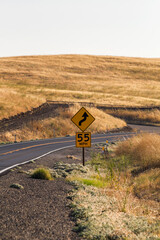 an beautiful, iconic and dreamy state road at the golden our CA-140 at catheys Valley, California. With a traffic sign shows 55 Miles per our speed limit and warning for curve