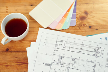 Color, swatch and planning home renovation with blueprint on table from above with interior design. Creative, ideas and decision for project in house with sketch of floor plan on desk in office