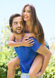 © peopleimages.com - Couple, piggy back and outside happy for relationship, bonding love and care in nature date for romance. Blue sky, trees and summer holiday with affection, fun and adventure in sunshine with support