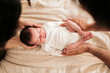 © ADDICTIVE STOCK - Newborn baby cradled gently in parent's hands