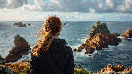 Poster - A woman gazes at the vast ocean from a high cliff. Suitable for travel and nature themes