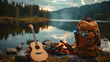 © Anna Iluschenko - September 27 is World Tourism Day. Recreation and travel concept: tourist backpack and guitar on the background of a campfire near a lake in the mountains.