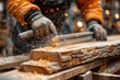 © familymedia - Woodworker in a workshop planing a wooden plank, with wood shavings flying