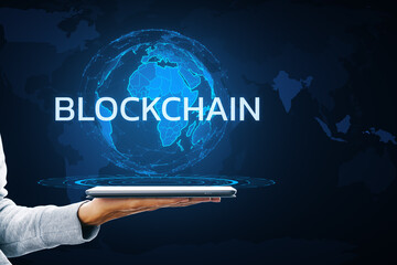 Aufkleber - A person's hand holding a tablet displaying a holographic globe with the word BLOCKCHAIN on a dark background with map outlines, illustrating a digital concept