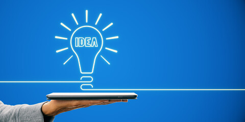 Aufkleber - Neon light bulb with 'IDEA' text above a tablet held by a person, against a blue background, representing creativity and innovation