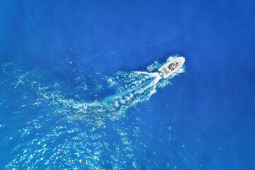Wall Mural - aerial view on fast boat on blue sea at sunny day. vacation and leisure. fast ship on the sea surfac