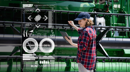 Poster - Woman farmer with digital tablet on a background of autonomous harvester. Smart farming concept