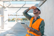 © Have a nice day  - Caucasian Male technician engineer construction worker working in building structure site wearing safety vest and helmet gears, using tablet device technology digital blueprint analyzing planning.