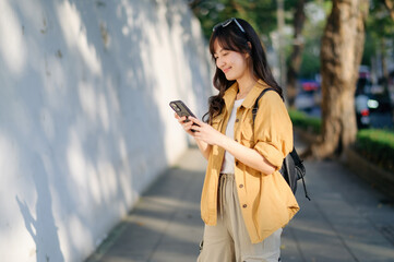 Wall Mural - Traveler young asian woman in her 30s uses her phone to capture Bangkok's vibrant energy. Connect, explore, and discover with her journey.