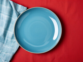 Wall Mural - Empty round blue plate on a colored background for food