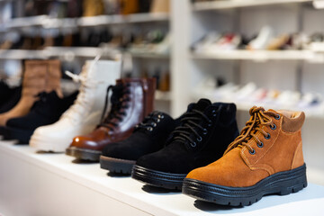 Wall Mural - Rows of new leather boots on shelves in shoe store.