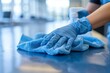© itchaznong - Closeup hand in blue rubber protective glove wiping and cleaning