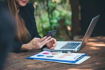 Poster - Asian Female freelance using laptop at home office desk. Woman reading financial graph chart Planning analyzing marketing data. Asian female people working office firm with business stuff, coffee cup