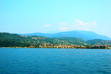 Wall Mural - Splendid view at Garda town on Lake Garda with the reddish Villa degli Albertini from the 16th century visible on the left side of the picture, with its magnolia trees, at the side of many buildings