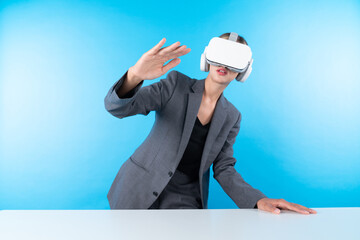 Wall Mural - Project manager wearing VR headset and standing while holding innovation technology hologram. Skilled businesswoman connect with visual reality world while looking at data for investment. Contraption.