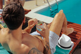Fototapeta  - Man enjoying his cod beverage on a sun lounger