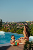 Fototapeta  - Out of focus shot of a poolside laughing young couple