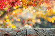 © grey - A wooden desk top with blurred background of maple tree with autumn foliage. Good for background