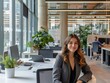 © AIGC JOE - A young business woman seated at a desk in a modern, well-lit office environment. The office is spacious and features contemporary design elements, including large windows that allow natural light.