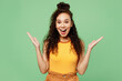 © ViDi Studio - Young surprised fun shocked woman of African American ethnicity wear yellow tank shirt top look camera spread hands say wow isolated on plain pastel light green background studio. Lifestyle concept.