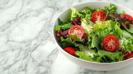 Wall Mural - A bowl of salad with lettuce, tomatoes, and other greens. The bowl is white and placed on a marble countertop
