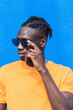© Frenchiebuddha - Fashion and confident African American man posing on blue background. Lifestyle concept