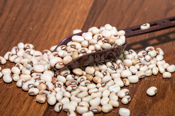 Cowpea, Heap of peas on wooden background. cow-peas on spoon