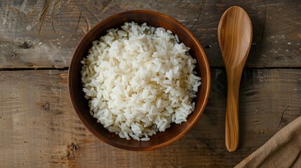 Poster - A wooden bowl filled with cooked white rice sits on a wooden table next to a wooden spoon. Generative AI
