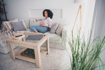 Wall Mural - Photo of charming adorable young woman sitting on couch cozy free time white light interior living room indoors