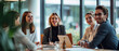 © Holly Berridge - Happy business team working together in a conference room, with the leader smiling and laughing during a meeting at the office table. Suitable for illustrating teamwork and collaboration in corporate