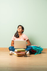 Indian asian girl child sitting on floor and using laptop computer