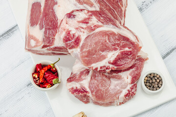 Wall Mural - Raw pork neck meat. Traditional ingredients for cooking food. Garlic cloves, fresh parsley