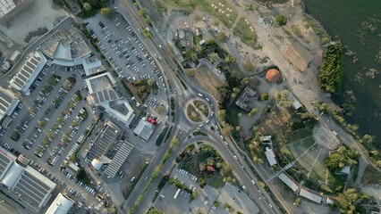 Wall Mural - Raising drone footage over cars around a circle cross road  with houses and trees