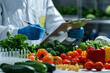 © Edgar Martirosyan - food scientist examining fresh vegetables and fruits in the laboratory,