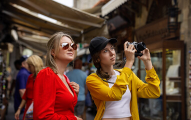 Wall Mural - Two tourists take photos in a crowded tourist city.