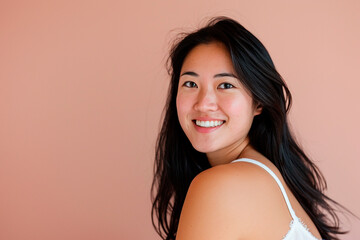 Wall Mural - A woman with long black hair is smiling at the camera