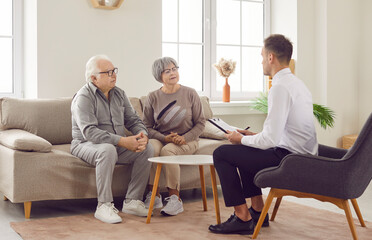 Young consultant, agent provides expert assistance to a senior client couple during home meeting. The discussion spans financial aspects, including investments, home purchases, insurance, and loans.