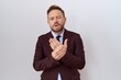 © Krakenimages.com - Middle age business man with beard wearing suit and tie suffering pain on hands and fingers, arthritis inflammation