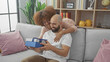 © Krakenimages.com - Interracial couple enjoys a cozy moment in a modern living room, sharing a surprise gift