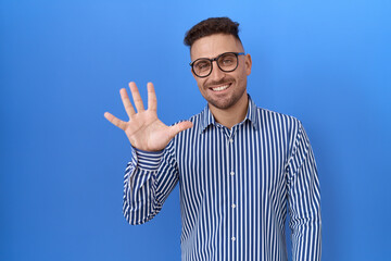 Poster - Hispanic man with beard wearing glasses showing and pointing up with fingers number five while smiling confident and happy.