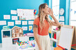 © Krakenimages.com - Young caucasian woman working as teacher at kindergarten shouting and screaming loud to side with hand on mouth. communication concept.