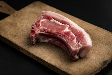 raw meat on wooden board and black background