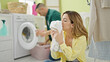 © Krakenimages.com - Man and woman couple sitting on floor together smelling clean towel at laundry room