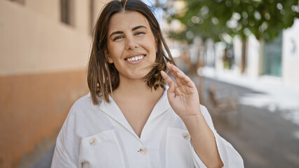 Poster - Young beautiful hispanic woman standing smiling at the city