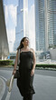 © Krakenimages.com - A smiling woman in casual attire holding a hat stands in front of the burj khalifa in dubai